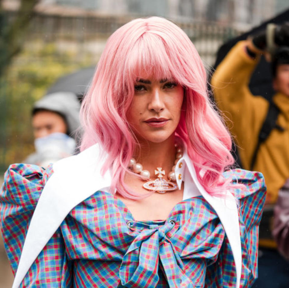 Clara Berry, wears blue and red checked mini dress with puff shoulders, Vivienne Westwood pearl necklace, white and green Vivienne Westwood bag, outside Vivienne Westwood, during the Womenswear Fall/Winter 2024/2025 as part of Paris Fashion Week on March 02, 2024 in Paris, France.