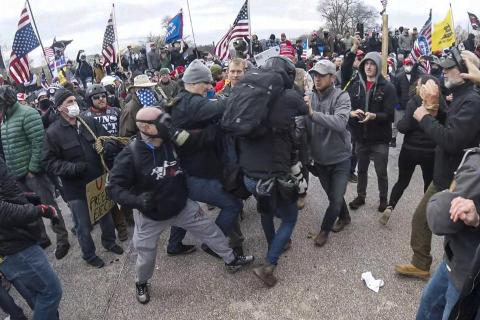 In this Jan. 6, 2021, image from video, Alan William Byerly, center, in gray skull cap, is seen allegedly attacking an Associated Press photographer during a riot at the U.S. Capitol in Washington. Byerly has been arrested on charges that he assaulted an Associated Press photographer and police officers. (AP Photo/Julio Cortez)