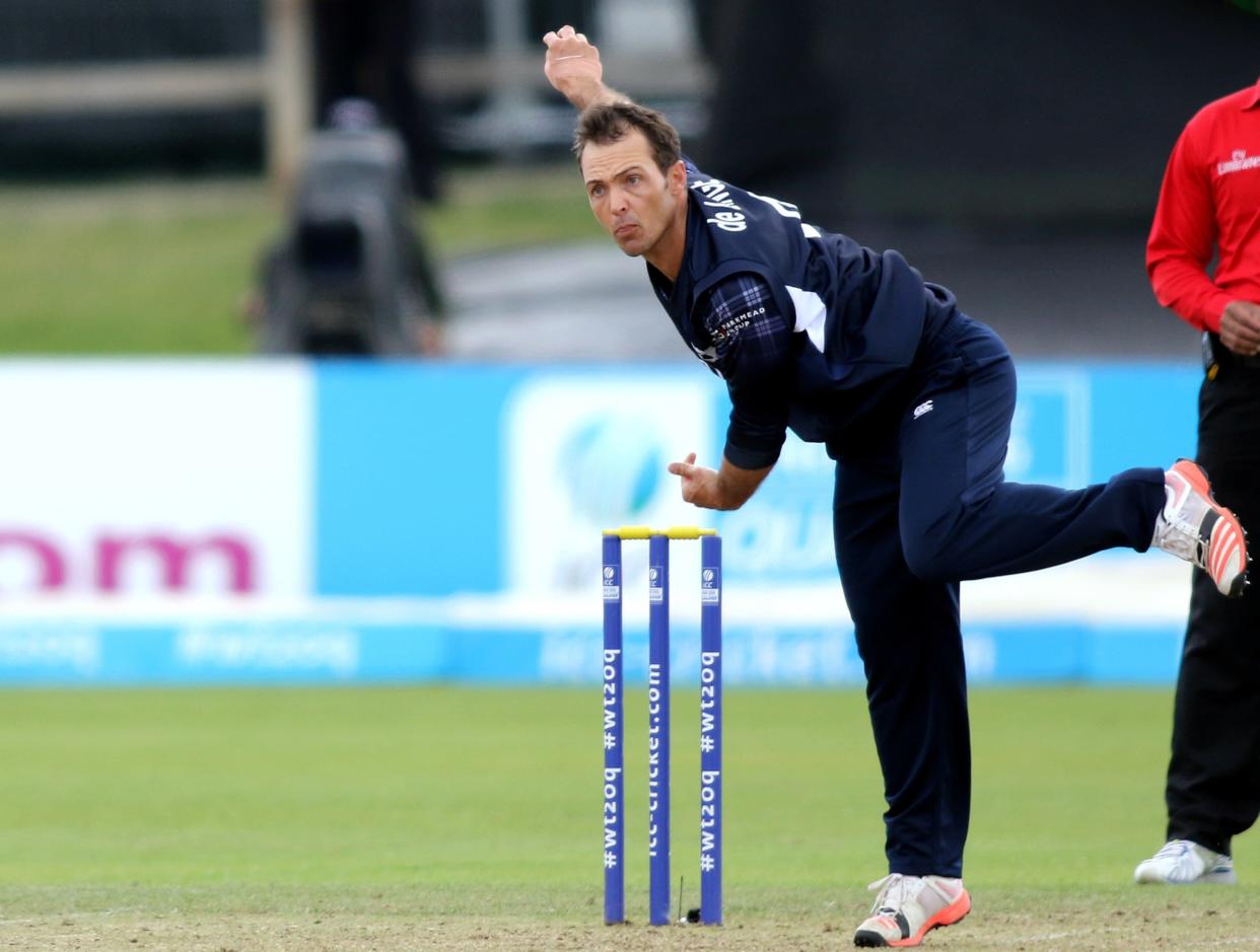 Scotland's Con De Lange bowls during the ICC World Twenty20 Qualifer between Scotland and Hong Kong at Malahide cricket club, north of Dublin on July 25, 2015. AFP PHOTO / PAUL FAITH        (Photo credit should read PAUL FAITH/AFP/Getty Images)