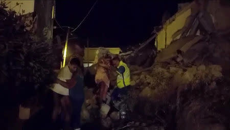 A woman is helped out of debris and rubble after an earthquake hit the island of Ischia, off the coast of Naples, Italy August 21, 2017 in this still image taken from video. MANDATORY CREDIT REUTERS/Vincenzo Precisano