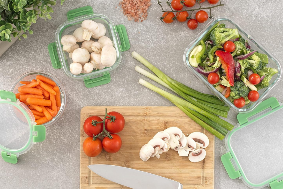 the glass food storage containers holding vegetables on a kitchen counter