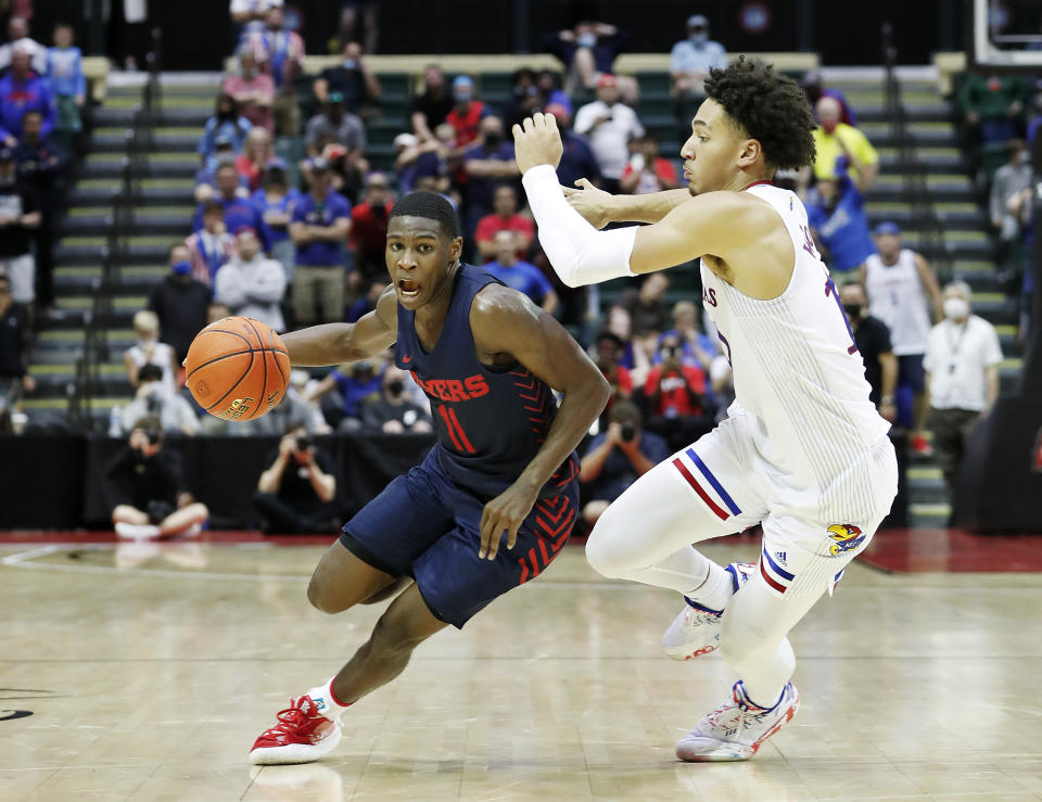 Kansas forward Jalen Wilson defends as Dayton guard Malachi Smith drives to the basket in the final seconds of the second half of an NCAA college basketball game Friday, Nov. 26, 2021, in Lake Buena Vista, Fla. (AP Photo/Jacob M. Langston)