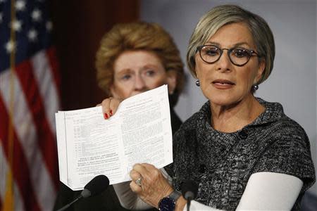 U.S. Senator Barbara Boxer (D-CA) (R) holds a copy of the Affordable Care Act (commonly known as Obamacare) to talk about provisions for women's health she says House Republicans are attempting to invalidate during the current fiscal battle at the U.S. Capitol in Washington, September 30, 2013. Looking on is Senator Debbie Stabenow (D-MI). REUTERS/Jonathan Ernst