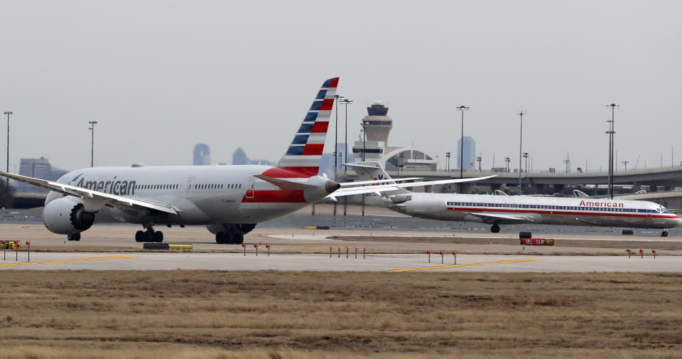 Jets line up on the tarmac at Dallas/Fort Worth International Airport in Grapevine, Dallas, Wednesday, Feb. 13, 2019. Flights at Dallas' two major airports were temporarily halted after air traffic controllers were forced to evacuate a building because of smoke, and the resulting flight delays are expected to continue for hours. (AP Photo/LM Otero)