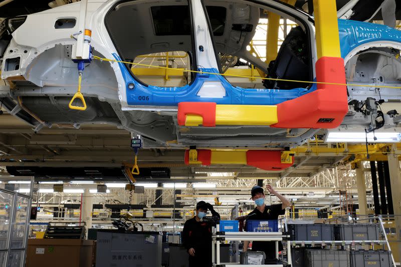 FILE PHOTO: Employees wearing face masks work on a Lynk &Co car production line at Geely's Yuyao plant in Ningbo