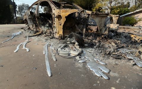 Molten aluminum has flowed from a car that burned in front of one of at least 20 homes destroyed just on Windermere Drive in the Point Dume area of Malibu, Calif. - Credit: AP