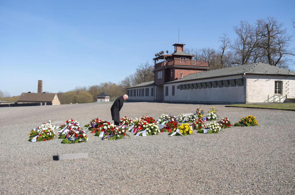 Volkhard Knigge, foundation director of the Nazi concentration camp Buchenwald memorial place, lays down a flower during a minute's of silence in memory of the victims at the 75th anniversary of the liberation of the former Nazi concentration camp Buchenwald by the US Army near Weimar, Germany, Saturday, April 11, 2020. Because of Corona crisis, the memorial is currently closed and all commemoration ceremonies with survivors have been cancelled. For most people, the new coronavirus causes only mild or moderate symptoms, such as fever and cough. For some, especially older adults and people with existing health problems, it can cause more severe illness, including pneumonia. (AP Photo/Jens Meyer)