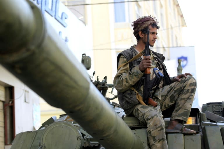 A Huthi rebel fighter is seen atop a tank in front of the residence of Yemen's former president Ali Abdullah Saleh in Sanaa on December 4, 2017