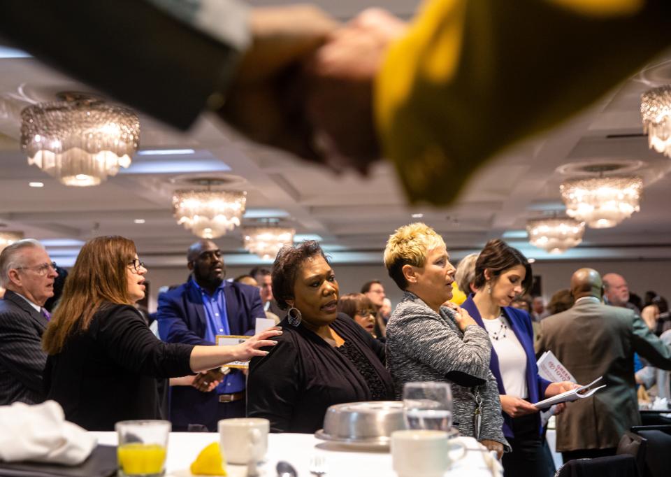 Rita Roach, center, and Kristin Doster, right, join hands as they sing "We Shall Overcome" during the annual Springfield Frontiers International Club Dr. Martin Luther King Jr. Memorial Breakfast at the Wyndham Springfield City Centre, Monday, Jan. 20, 2020, in Springfield, Ill. [Justin L. Fowler/The State Journal-Register]  