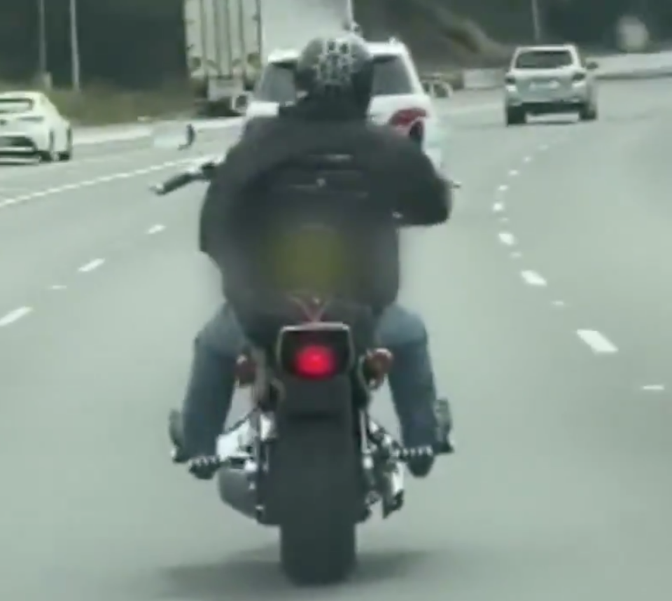 Motorbike rider shown before covering his licence plate with card to avoid paying Sydney's M4 toll charge.