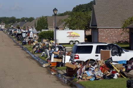 Piles of debris are seen in front of flood damaged homes in St. Amant, Louisiana. REUTERS/Jonathan Bachman