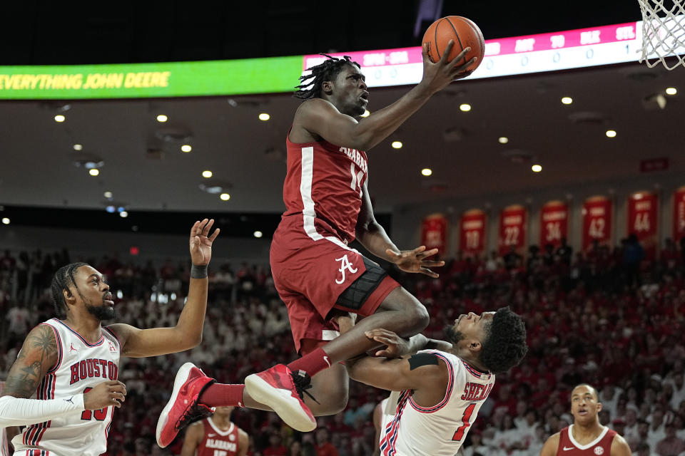 Alabama center Charles Bediako (14) is fouled by Houston guard Jamal Shead (1), right, during the first half of an NCAA college basketball game, Saturday, Dec. 10, 2022, in Houston. (AP Photo/Kevin M. Cox)
