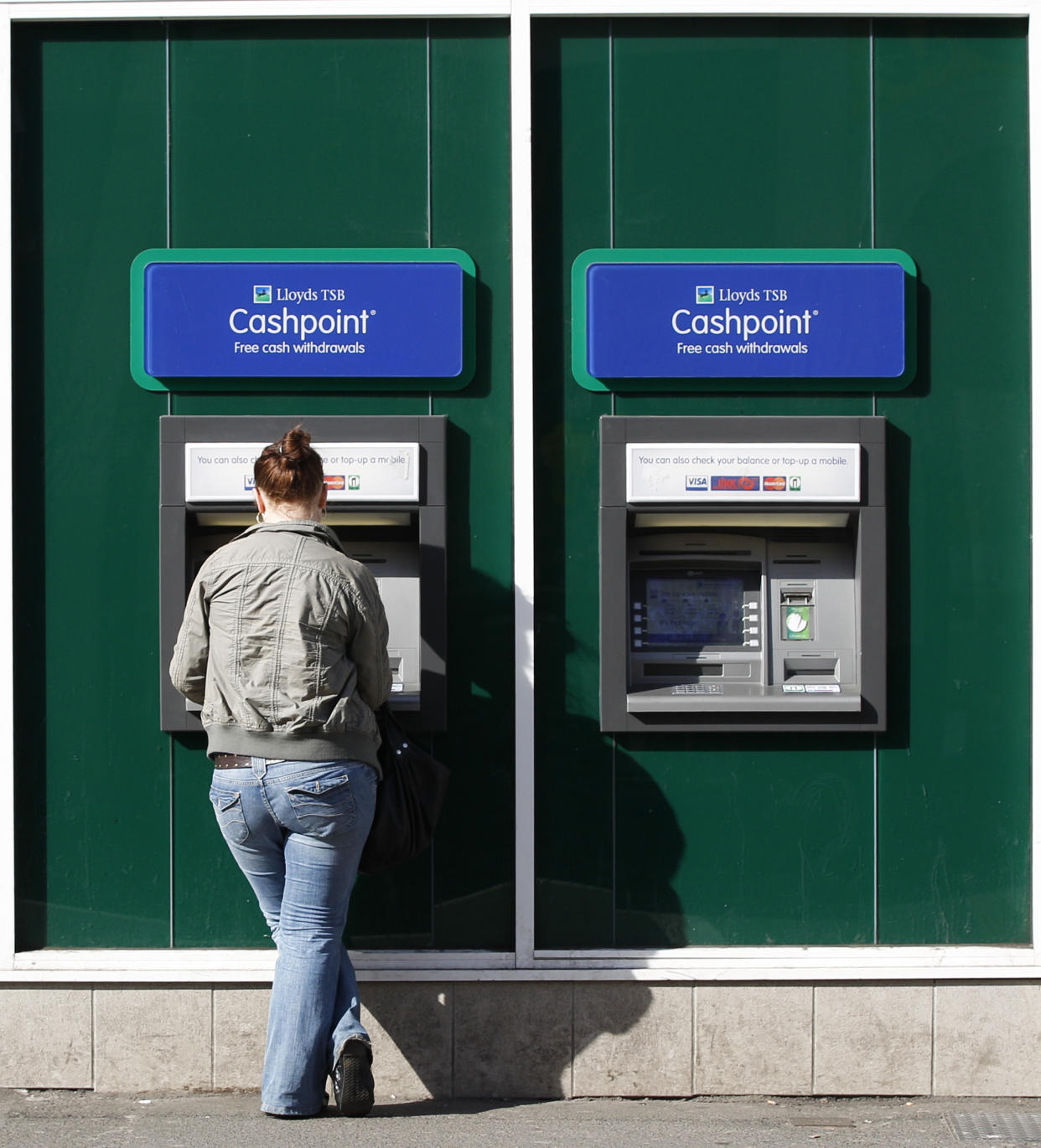 A woman uses a Lloyds TSB Cashpoint machine in Loughborough, central England April 27, 2010.  Lloyds Banking Group returned to profit in the first three months of this year, earlier than expected, as losses on both retail and commercial bad debts for Britain's largest bank continue to fall.  REUTERS/Darren Staples   (BRITAIN - Tags: BUSINESS)