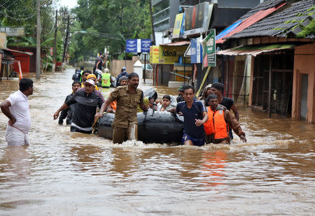 Rescuers evacuate people from a flooded area to a safer place in Aluva in Kerala, August 18, 2018. REUTERS/Sivaram V