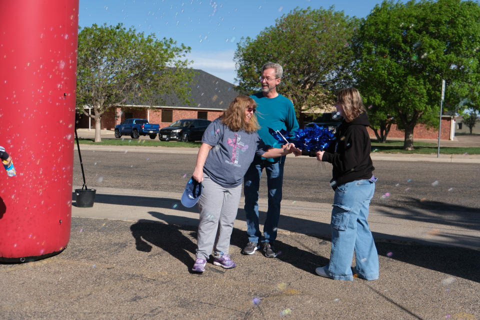 A finisher receives a pinwheel at the finish line Saturday at the "Walk a Mile in Their Shoes,” a one-mile run/walk event at The Bridge Children's Advocacy Center in Amarillo.