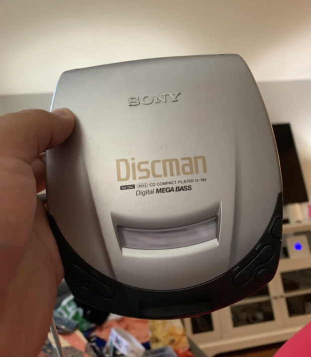 Hand holding a Sony Discman CD player with digital mega bass