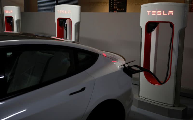 A Tesla car charges at a Supercharger station in Singapore