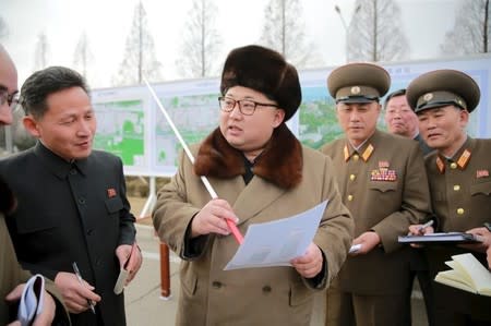 North Korean leader Kim Jong Un (C) speaks at an event declaring the construction of Ryomyong Street, in this photo released by North Korea's Korean Central News Agency (KCNA) in Pyongyang on March 18, 2016. REUTERS/KCNA