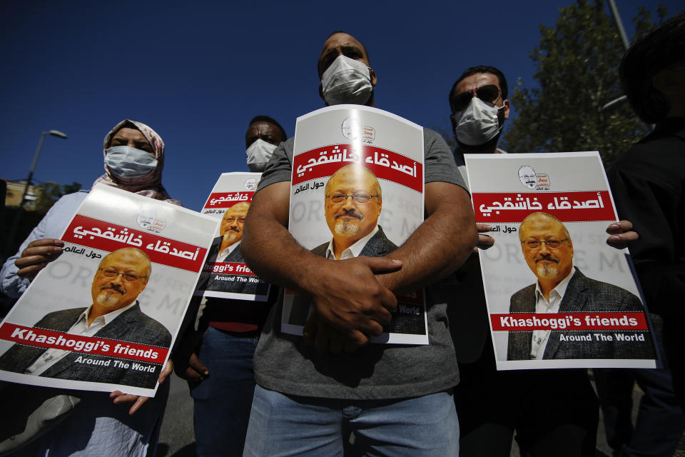 People hold posters of slain Saudi journalist Jamal Kashoggi, near the Saudi Arabia consulate in Istanbul, during an event marking the two-year anniversary of his death, Friday, Oct. 2, 2020. The gathering was held outside the consulate building, starting at 1:14 p.m. (1014 GMT) marking the time Khashoggi walked into the building where ehe found tragic death. The posters read in Arabic:' Khashoggi's Friends Around the World'. (AP Photo/Emrah Gurel)