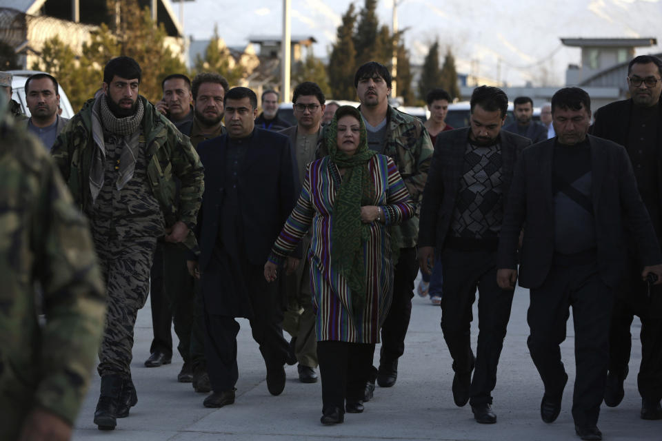 Hawa Alam Nuristani, center, chief of the Election Commission of Afghanistan, center, arrives for a press conference at the Independent Election Commission office in Kabul, Afghanistan, Tuesday, Feb. 18, 2020. The Afghan Independent Election Commission said Tuesday that President Ashraf Ghani has won a second term as president. (AP Photo/Rahmat Gul)