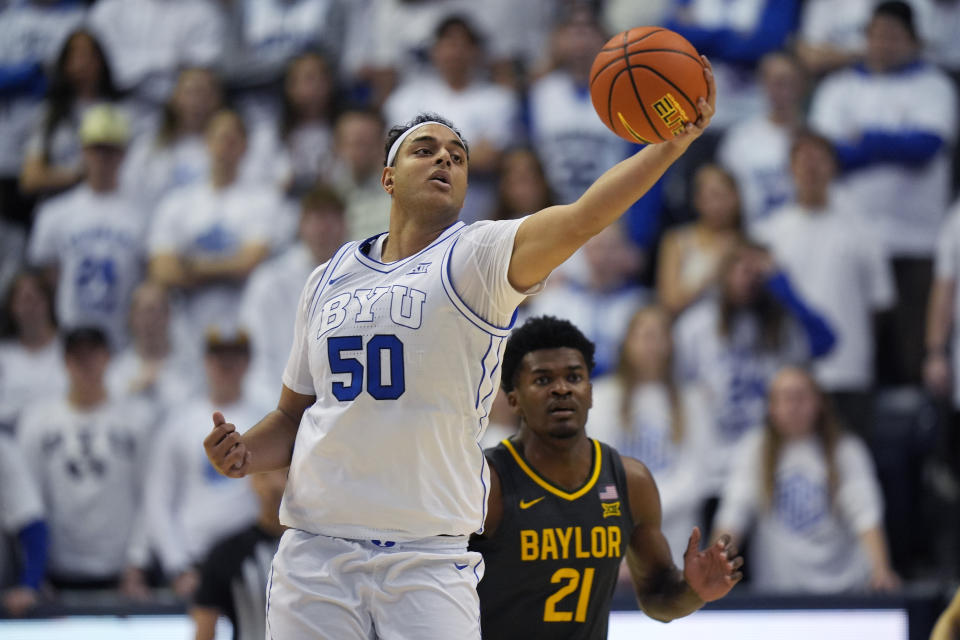 BYU center Aly Khalifa (50) catches a pass as Baylor center Yves Missi (21) looks on during the first half of an NCAA college basketball game Tuesday, Feb. 20, 2024, in Provo, Utah. (AP Photo/Rick Bowmer)