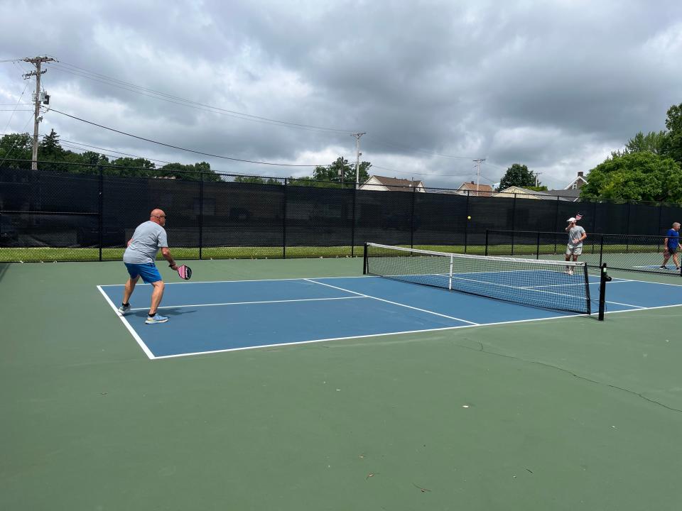 Brent Oswald, left, of Green and his son Jacob Oswald play pickleball Saturday at one of North Canton's four pickleball courts on Glenwood Street NE by South Main Street. Plain Township this September will be the latest Stark County community to have pickleball courts in its parks system.