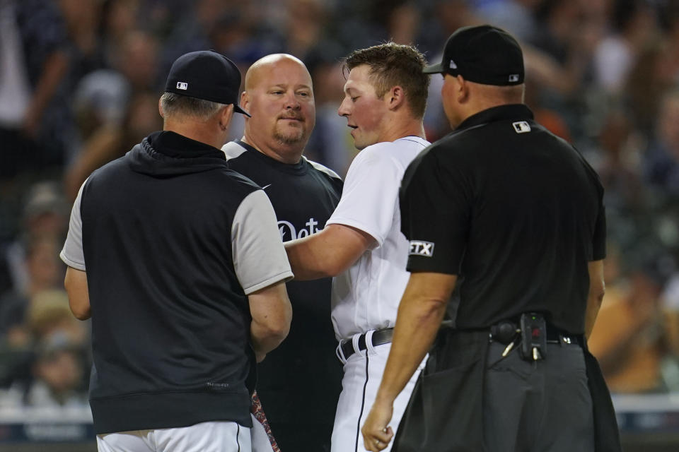 Detroit Tigers' Spencer Torkelson, third from left, is checked on by manager A.J. Hinch, left, and athletic trainer Doug Teter after being hit in the head by a pitch in the seventh inning of a baseball game against the Kansas City Royals in Detroit, Friday, July 1, 2022. Torkelson left the game. (AP Photo/Paul Sancya)