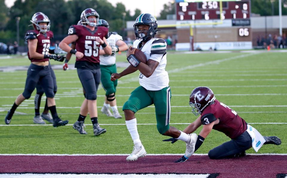 Edmond Santa Fe's Malikai Miller celebrates a touchdown against Edmond Memorial on Friday.