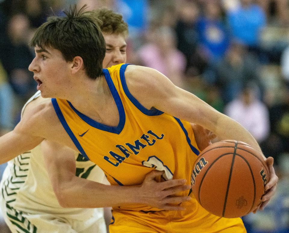 Alex Couto of Carmel High School is fouled by a Westfield High School defender at Carmel High School, Tuesday, Feb. 28, 2023, during the Westfield boys’ sectional win over Carmel, 43-40. 