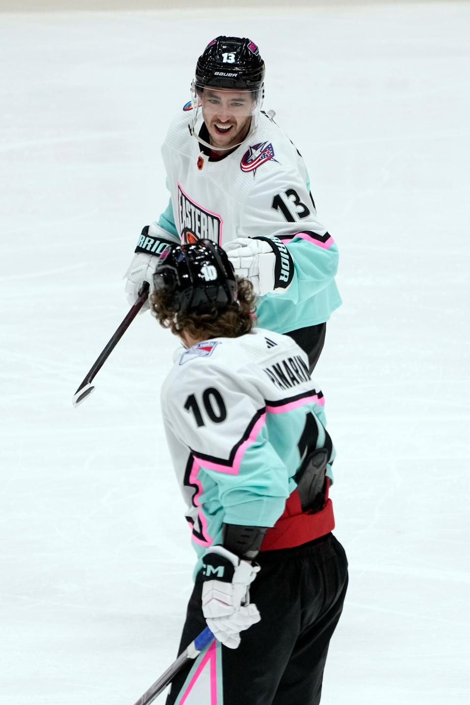 Blue Jackets forward Johnny Gaudreau (13) celebrates with the Rangers' Artemi Panarin after scoring a goal during the NHL All-Star Game.