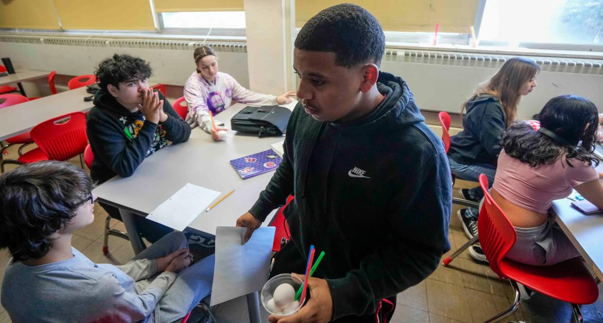 Audubon High School student Elias Moreno helps pass out eggs for an activity in which groups have to work together to figure out how to keep the egg safe after dropping it from a certain distance.