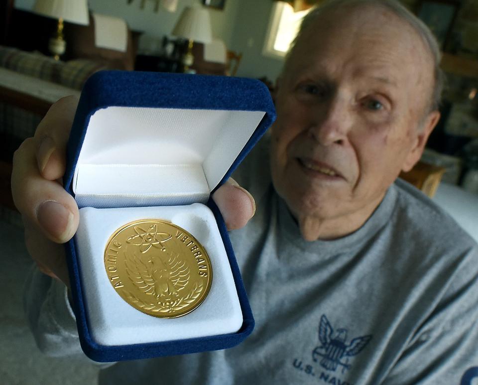 Navy veteran Tom Hoffman of Monroe shows the Atomic Veterans Commemorative Service certificate and gold medal he recently received from U.S. Defense Department for nuclear testing he performed decades ago.