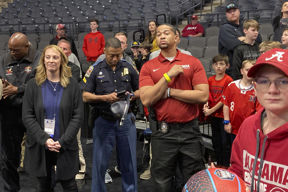 An unidentified armed security guard, wearing a crimson Alabama basketball shirt, watches as Alabama practices at the NCA college basketball tournament, Wednesday, March 15, 2023, in Birmingham, Ala. Alabama star Brandon Miller was accompanied by an armed security guard to the NCAA Tournament on Wednesday because of threats directed his way, Crimson Tide coach Nate Oats said. Miller's name surfaced last month in court testimony involving the capital murder case of former Alabama player Darius Miles and another man, who are charged in the fatal shooting of 23-year-old Jamea Harris on Jan. 15. (AP Photo/Paul Newberry)