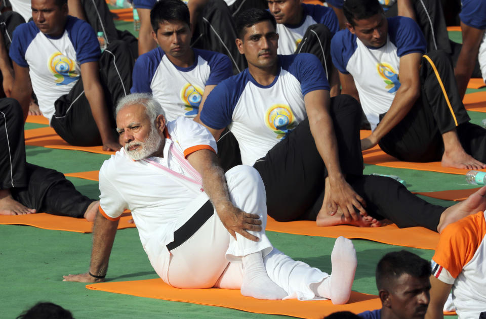 FILE-Indian Prime Minister Narendra Modi performs yoga to mark International Day of Yoga in Dehradun, India, Thursday, June 21, 2018. India's Prime Minister Narendra Modi, known for his reputation of an ascetic, is participating in a yoga session at the U.N. during his three-day visit to the United States. Wednesday's event is aimed to raise awareness worldwide of the benefits of practicing yoga, some nine years after the Hindu nationalist leader successfully lobbied the U.N. to designate June 21 International Yoga Day. Modi has harnessed yoga as a cultural soft power to extend his nation's diplomatic reach and assert his country's rising place in the world. (AP Photo/Manish Swarup, File)