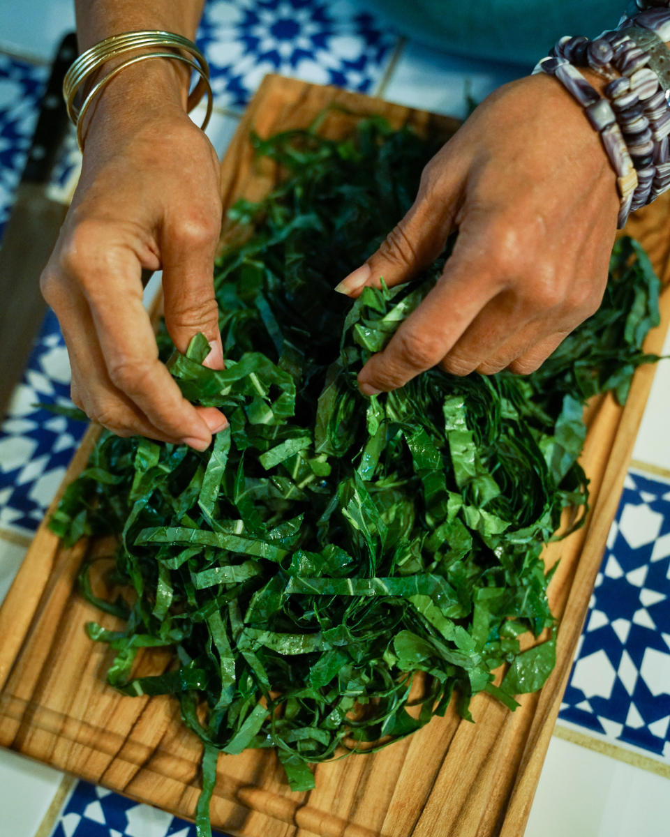 Harris fluffs the ribbons of collard greens before washing them again. (Kara Birnbaum / TODAY)