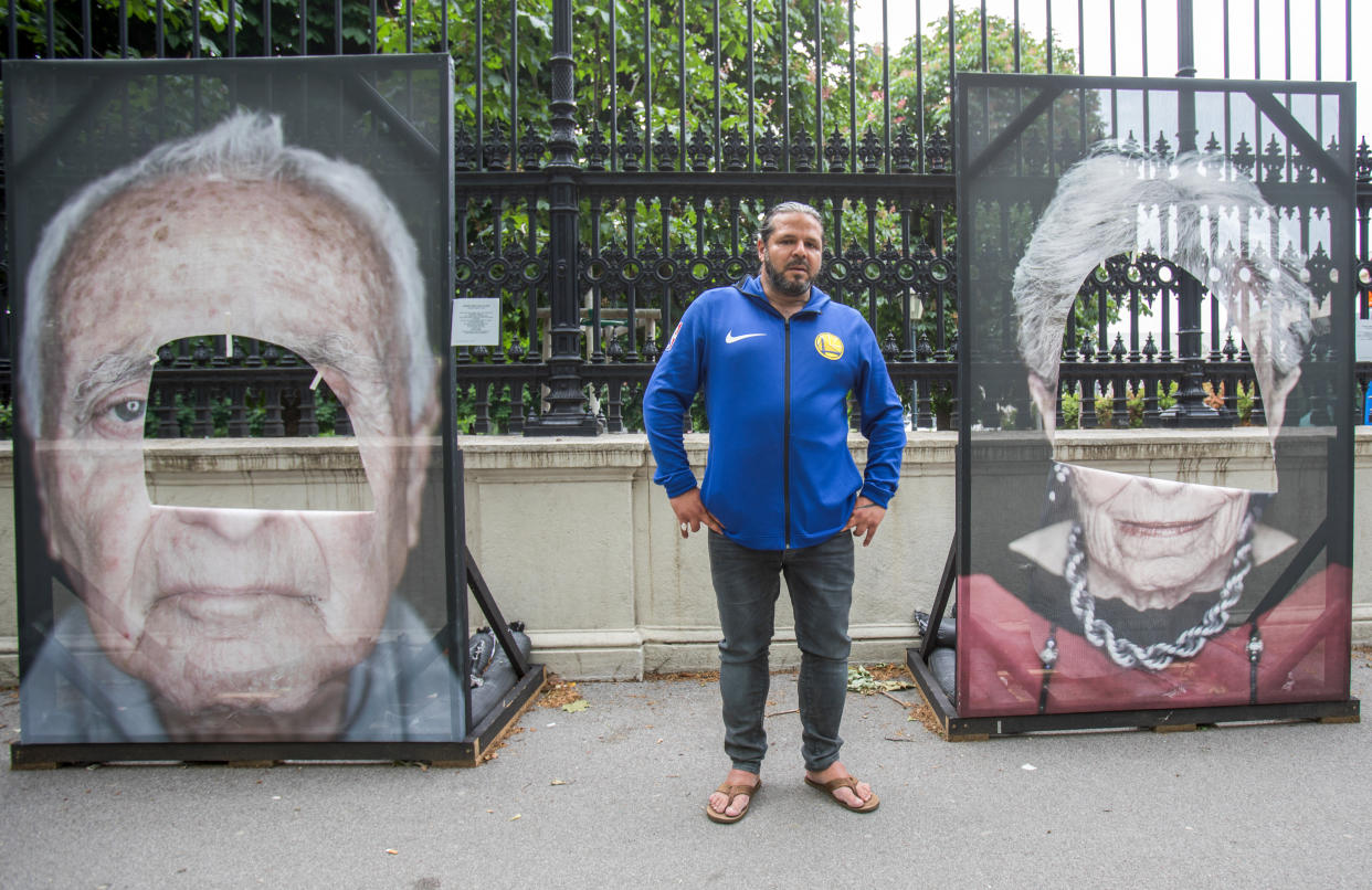 Fotograf Luigi Toscano mit zwei der beschädigten Porträts (Bild: Alex Halada/AFP)