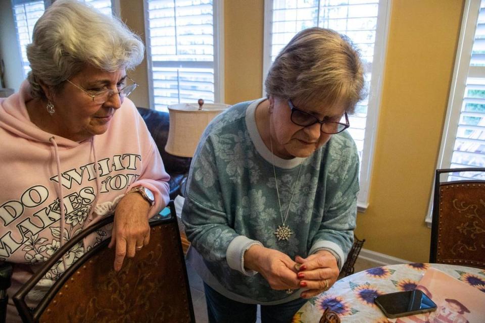 Terry, right, and Lilly look at the coins that Lilly gave Terry more than 60 years ago, right before Terry’s family left for America.