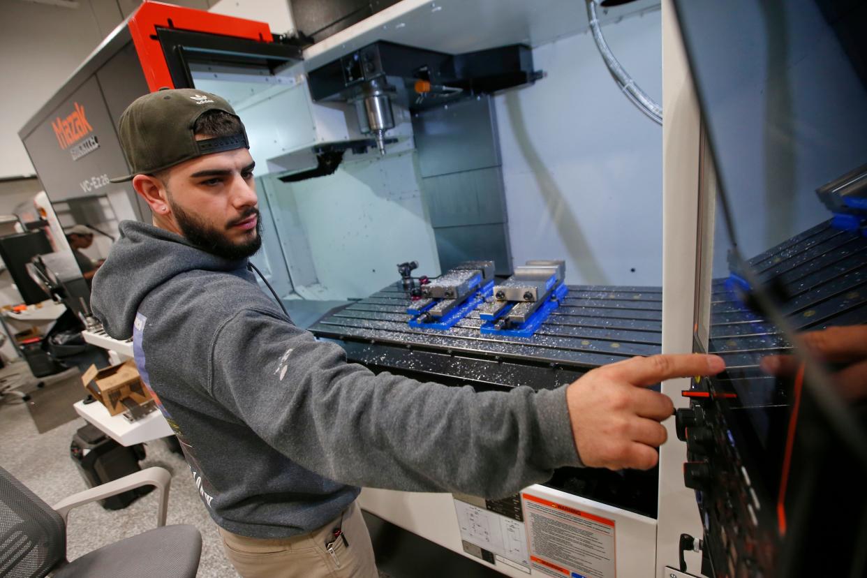 Alan Chaves programs a multi axis CNC machine at the new Proto XYZ manufacturing facilty on Potomska Street in New Bedford.