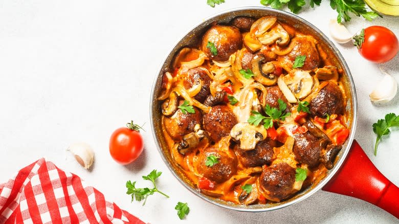 Meatballs in pan surrounded by tomatoes 