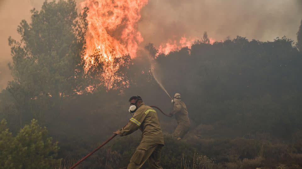 Firefighters battle flames during a wildfire near Prodromos on August 21, 2023.  - Spyros Bakalis/AFP/Getty Images