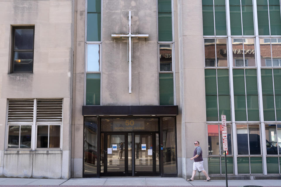 A man walks by the offices of the Diocese of Rockville Centre, Thursday, Oct. 1, 2020, in Rockville Centre, N.Y. The diocese filed for bankruptcy on Thursday because of financial pressure from lawsuits over past sexual abuse by clergy members. (AP Photo/Mark Lennihan)