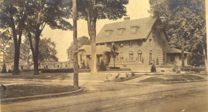This photo shows a wide view of the Calendar GH Wood residence on East Elm Avenue in Monroe, circa the 1920s. The gardens designed by Greening included a large pergola and other structural features.  This house has been well preserved and looks great today.