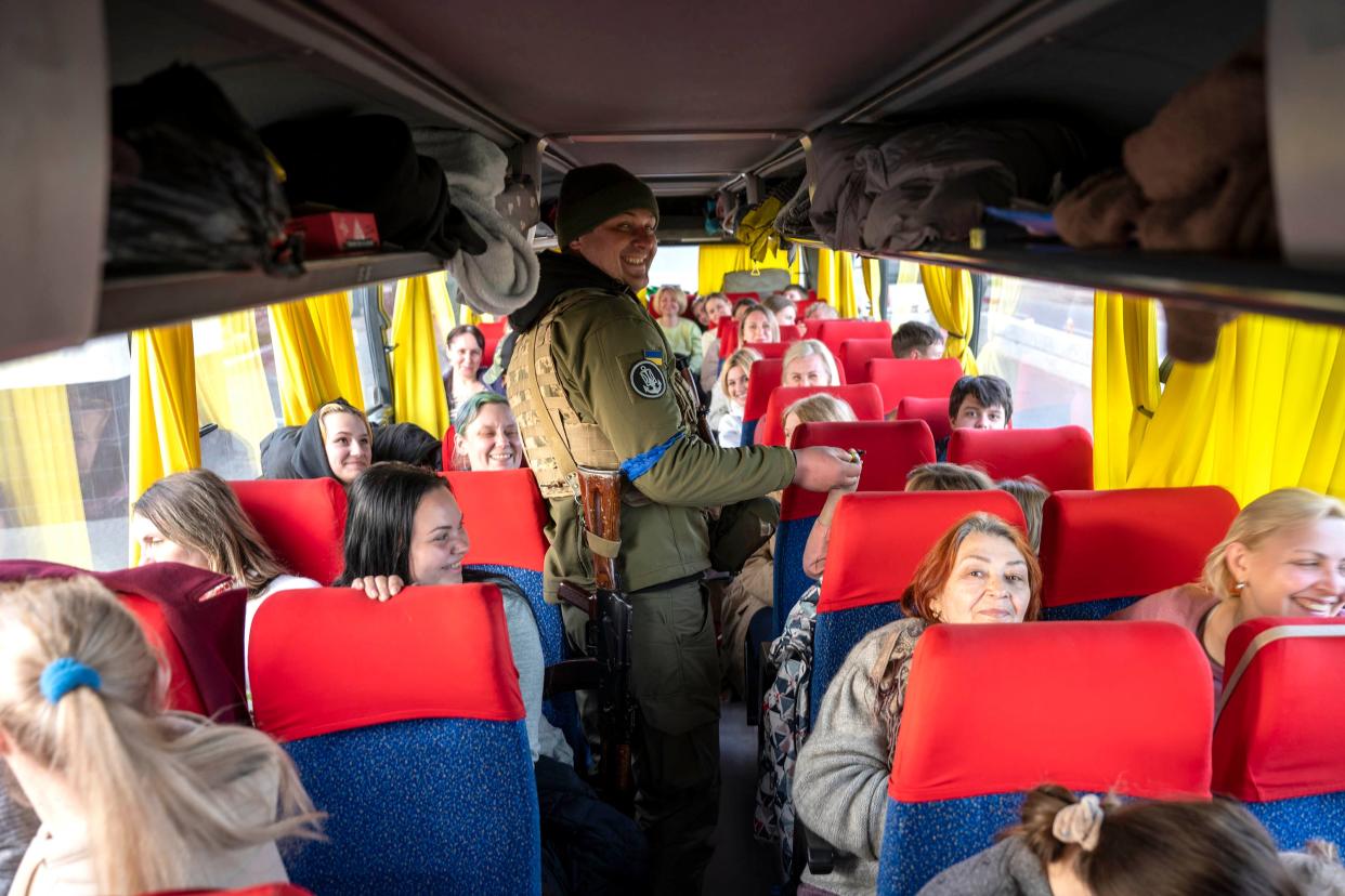 A Ukrainian soldier offers candy to children aboard a Team Humanity bus bound for Chisinau, Moldova, after evacuating nearly 160 people from Mykolaiv on April 7, 2022. This story was produced in partnership with the Pulitzer Center.