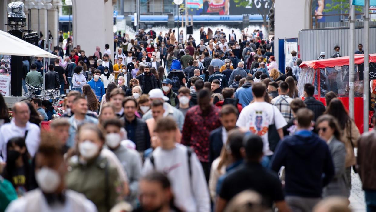 Zahlreiche Menschen spazieren durch die Fußgängerzone in der Innenstadt.