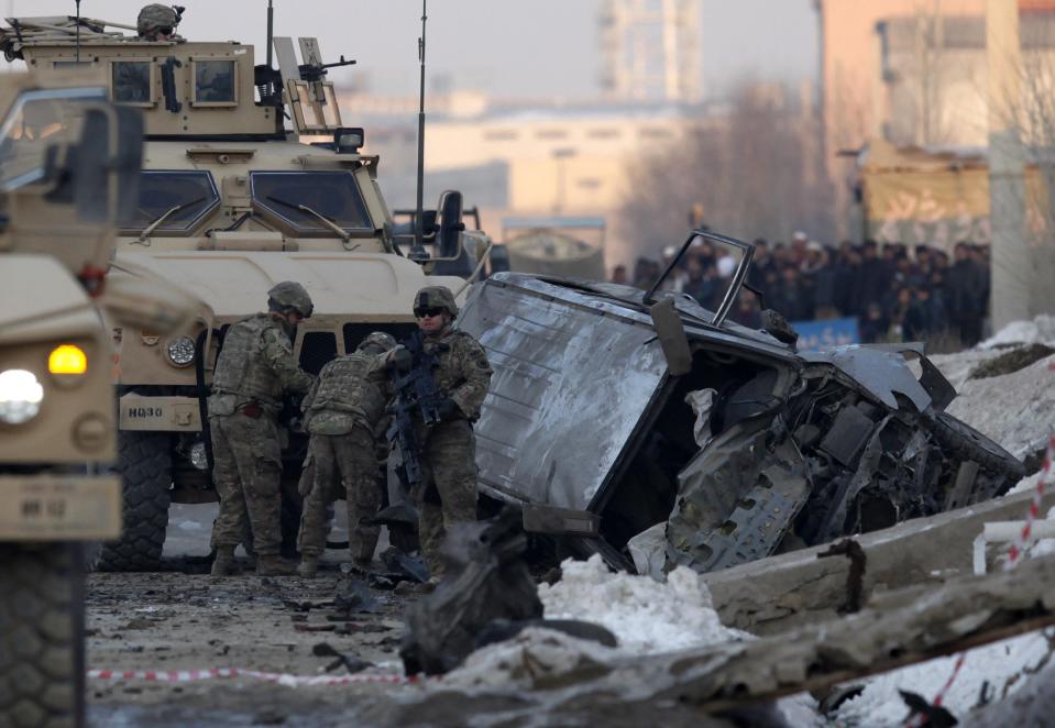 U.S. troops investigate at the site of a suicide car bomb attack in Kabul