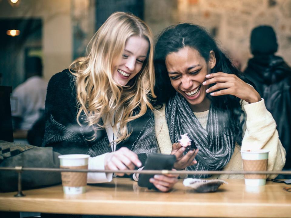 women laughing together in a coffee shop