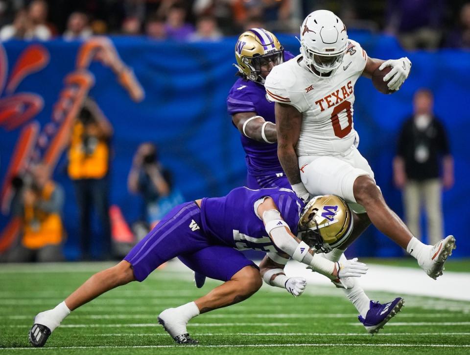 Texas Longhorns tight end Ja’Tavion Sanders (0) evades a tackle from Washington Huskies cornerback Jabbar Muhammad (1) and cornerback Kamren Fabiculanan (13) in the fourth quarter of the Sugar Bowl College Football Playoff semi-finals at the Ceasars Superdome in New Orleans, Louisiana, Jan. 1, 2024. The Huskies won the game 37-31.