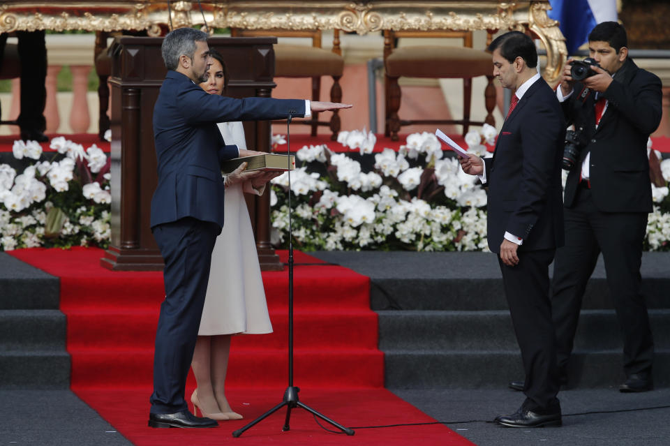 El nuevo presidente de Paraguay, Mario Abdo Benítez, flanqueado por su esposa Silvana López, presta juramento en el palacio presidencial en Asunción, Paraguay, el miércoles 15 de agosto de 2018. (AP Foto / Jorge Saenz))