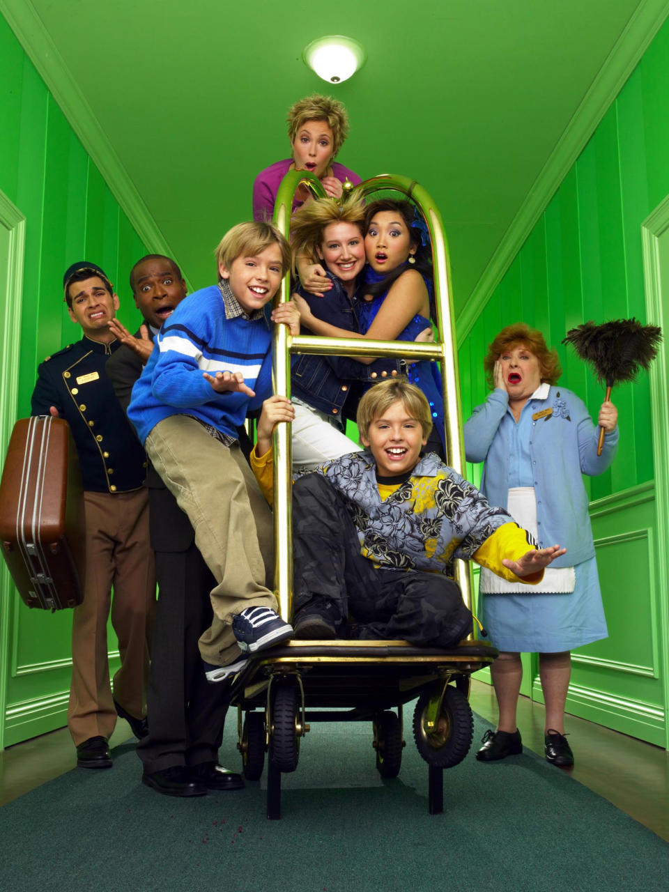 The cast of The Suite Life of Zack and Cody ride on a luggage cart