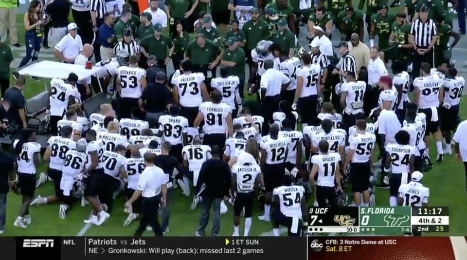 Players gather around McKenzie Milton. (via ESPN)